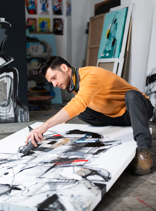 Künstler bearbeitet großfomatige Leinwand