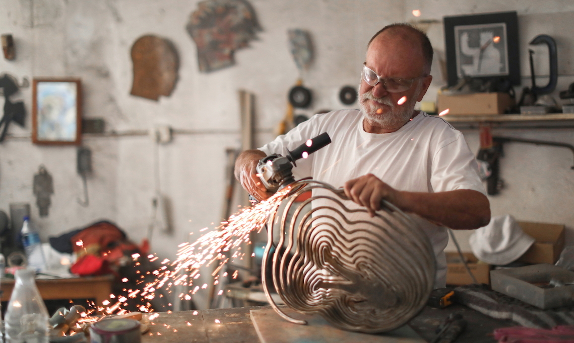 Künstler schweisst an einer Metall-Skulptur